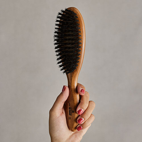手に持ったGB KENTの天然豚毛ヘアブラシ