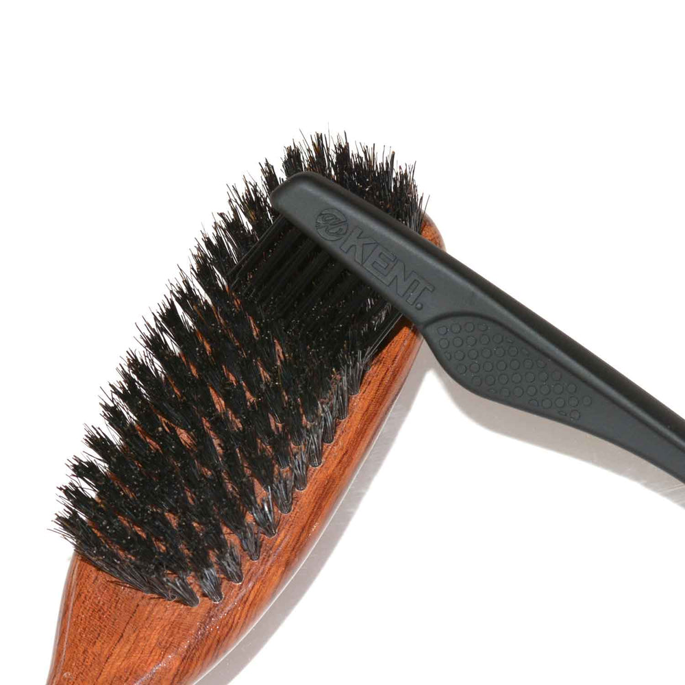 クリーニングブラシで豚毛ヘアブラシの抜け毛を取り除く様子